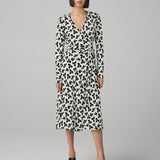 Woman wearing a leopard print dress on a gray background