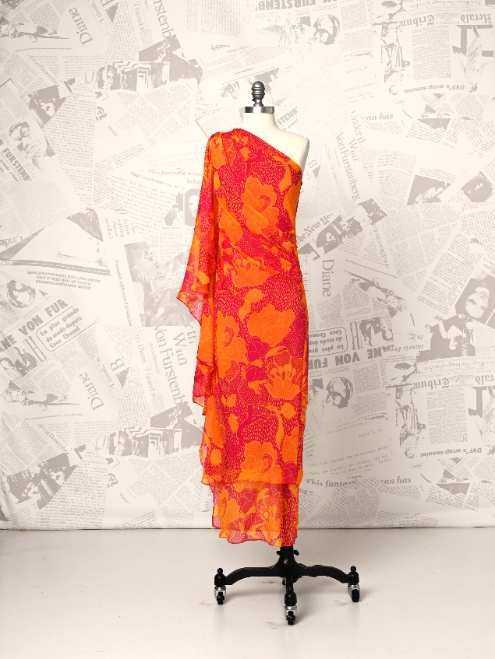 Orange floral dress on a mannequin against a newspaper background