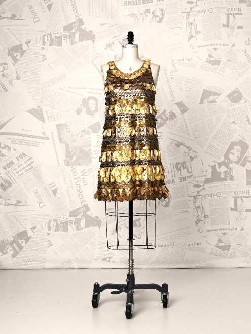Mannequin wearing a patterned dress against a newspaper background